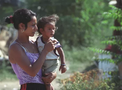 A Roma girl with a baby in her arms