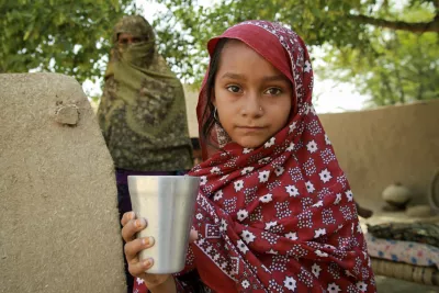 A girl holds a glass of water
