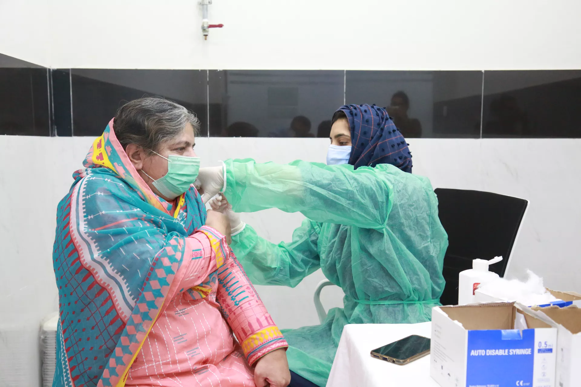 A frontline health worker wearing PPEs administers the COVID-19 vaccine in Pakistan. 