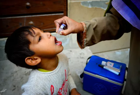 A five year old boy receives the polio vaccine from Shumaila, a polio vaccinator in Lahore.