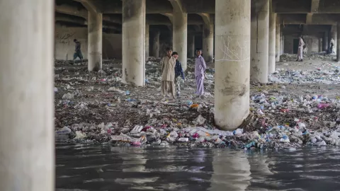 children standing near sewage in karachi