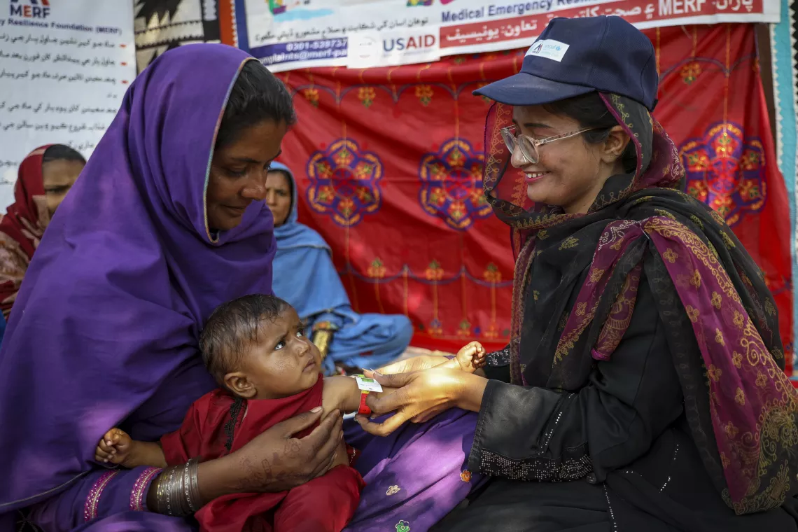 Nutrition Assistant Umbreen measures Shabira’s mid-upper arm circumference to check for malnutrition.