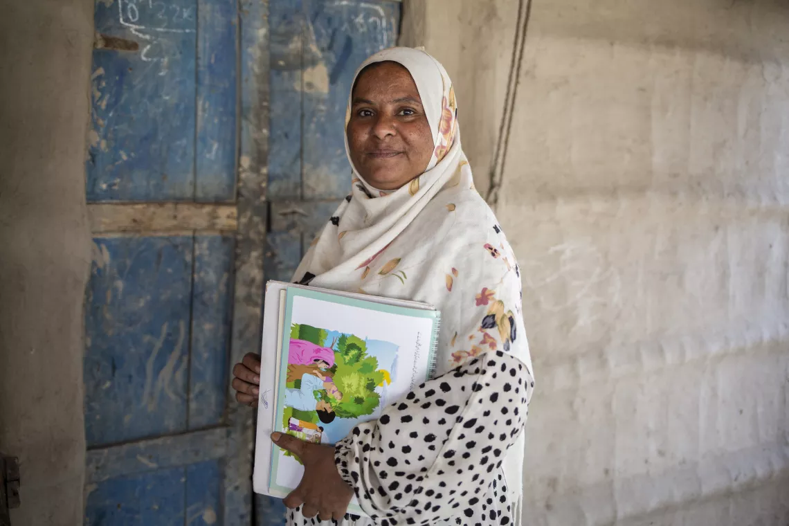 Roshan, a Lady Health Worker, holds a booklet of information about Multiple Micronutrient Supplements, in Thatta, Sindh Province.