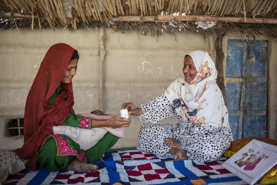 Roshan, right, speaks with Rozan about the benefits of Multiple Micronutrient Supplements in Thatta, Sindh Province.
