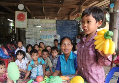 طفل يرفع موز من البلاستيك في فصل دراسي في روضة محلية للأطفال في كومونة سوكانغ، كمبوديا عام 2015.