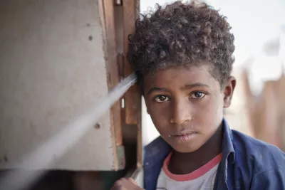 Yemen. A boy stands in the doorway of his family’s shelter.