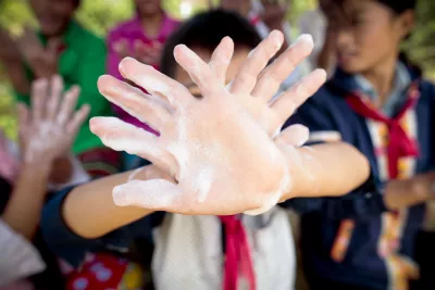 Des enfants prennent plaisir à se laver les mains avec du savon et de l’eau propre.