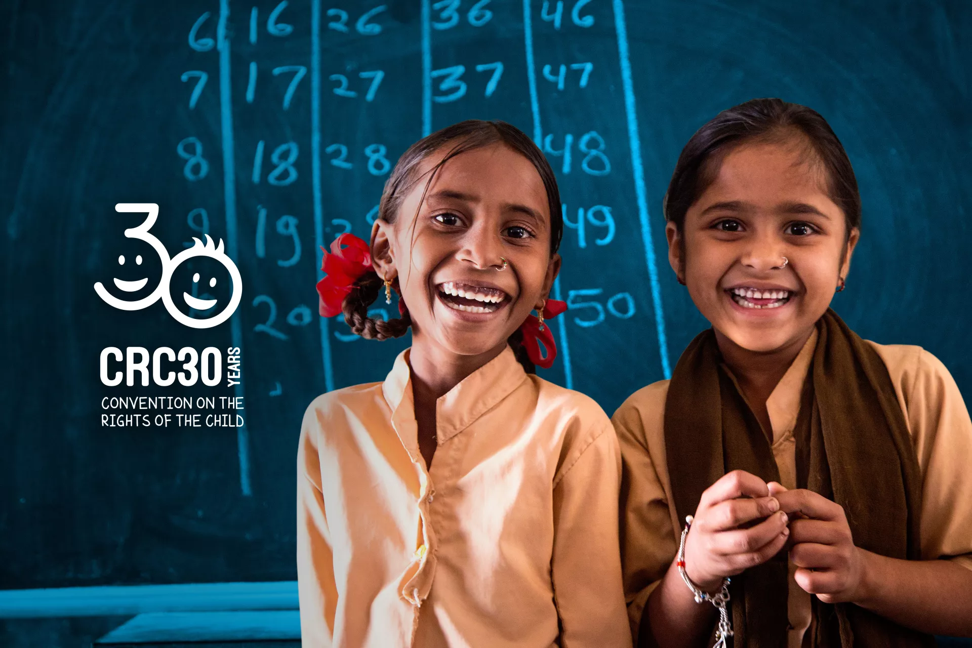 Convention on the Rights of the Child: A 7-year-old student and her best friend stand together in a school classroom in India.