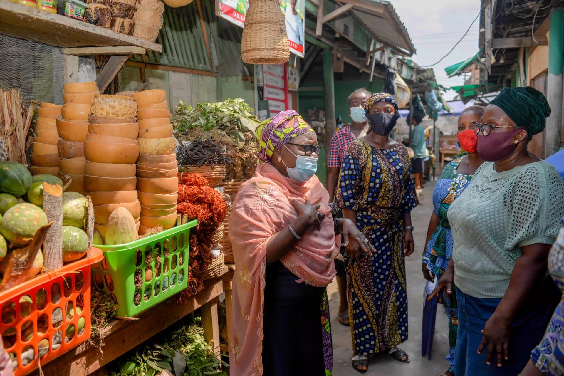 Des femmes portant des masques discutent dans un marché