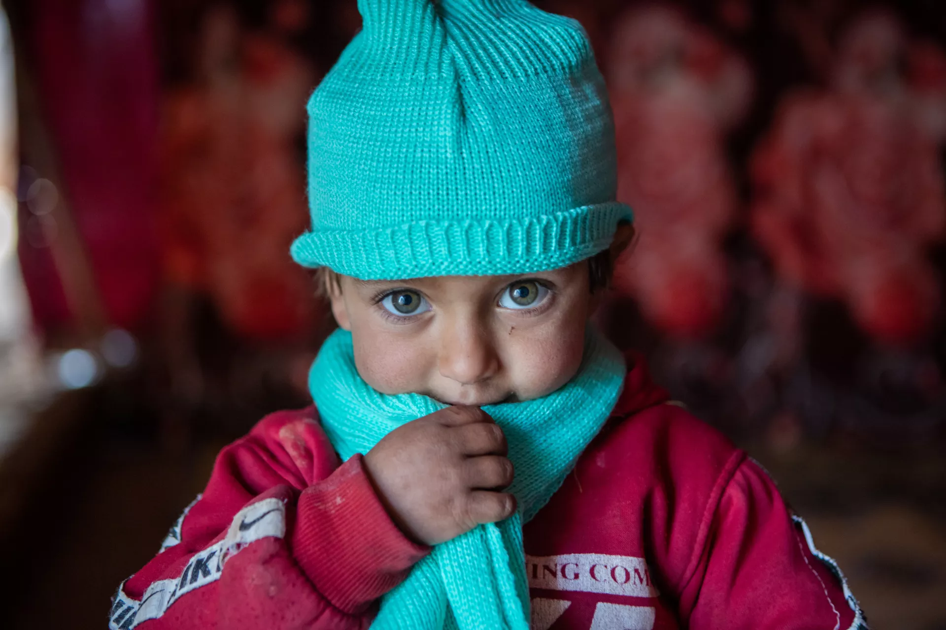 On 22 January 2022, three-year-old Kawthar wears her new woollen hat and scarf, received as part of the winter clothing kits UNICEF distributed in Alzhourieyh makeshift camp, east rural Homs, Syria.