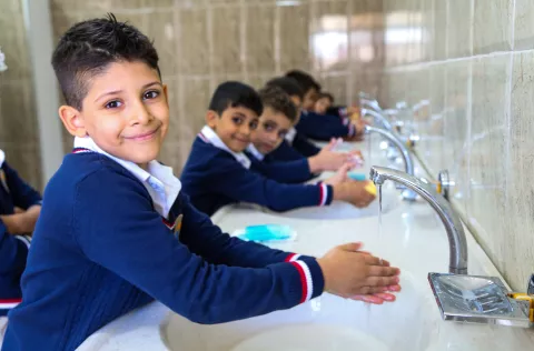 Children wash their hands in school.