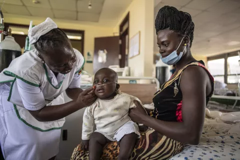 Nakato Sarah has her baby Constance Prosper Waida seen by a nurse in Kayunga, Uganda.