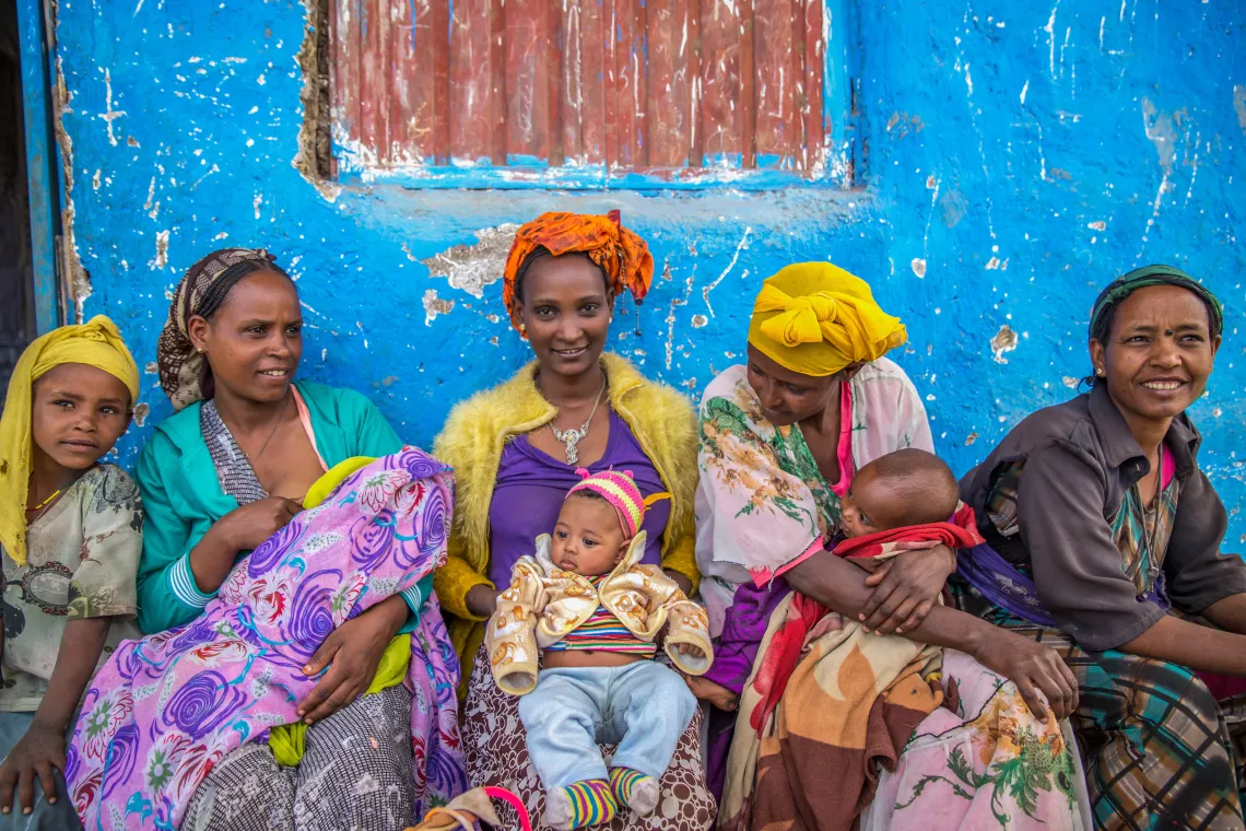 أمهات بصحبة أطفالهن ينتظرن خارج عيادة واشي فاكا الصحية في ماريكو وريدا، وهي إحدى المناطق المتأثرة بالجفاف في إثيوبيا، حيث توفر اليونيسف دعماً صحياً وغذائياً.