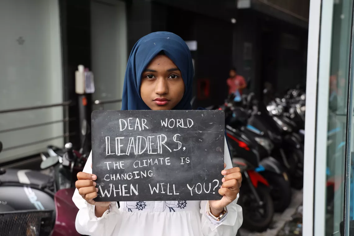 Una niña con un cartel dirigido a los líderes mundiales.