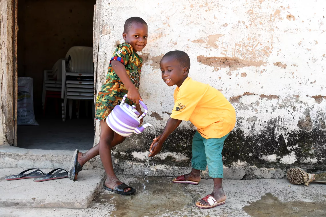 Two children washing their hands in Côte d’Ivoire.