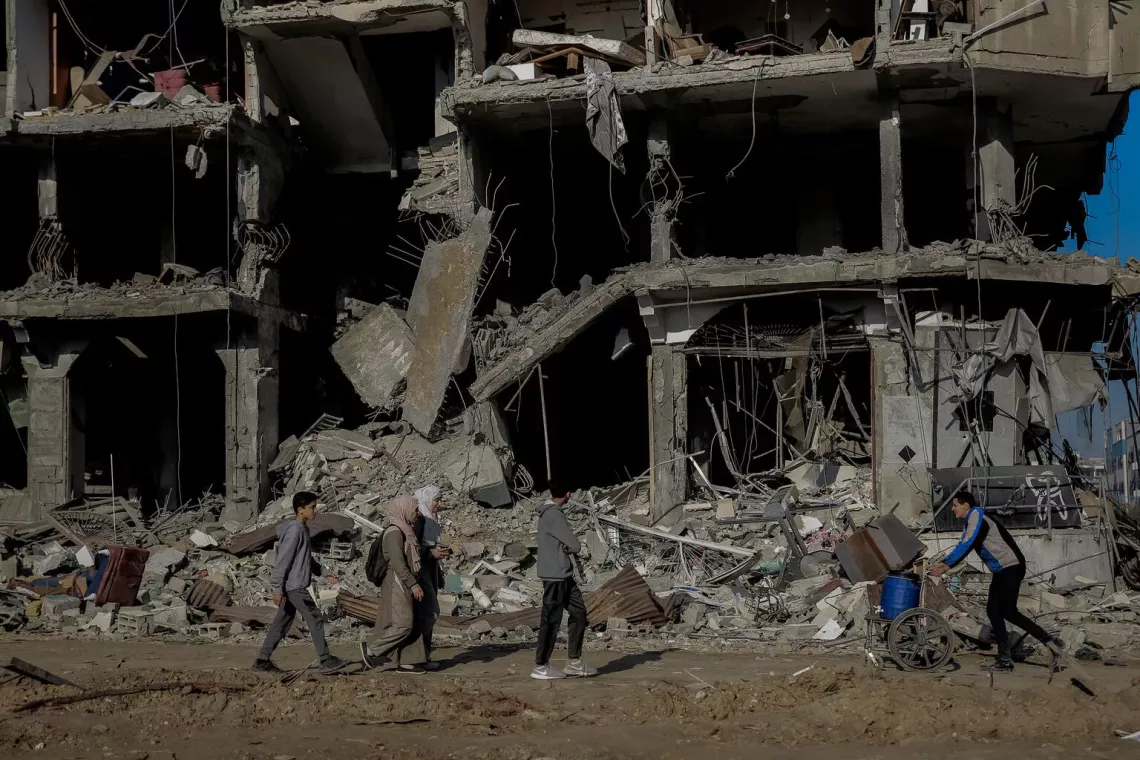 Gaza Strip. People walk past destroyed buildings in the centre of Gaza City.