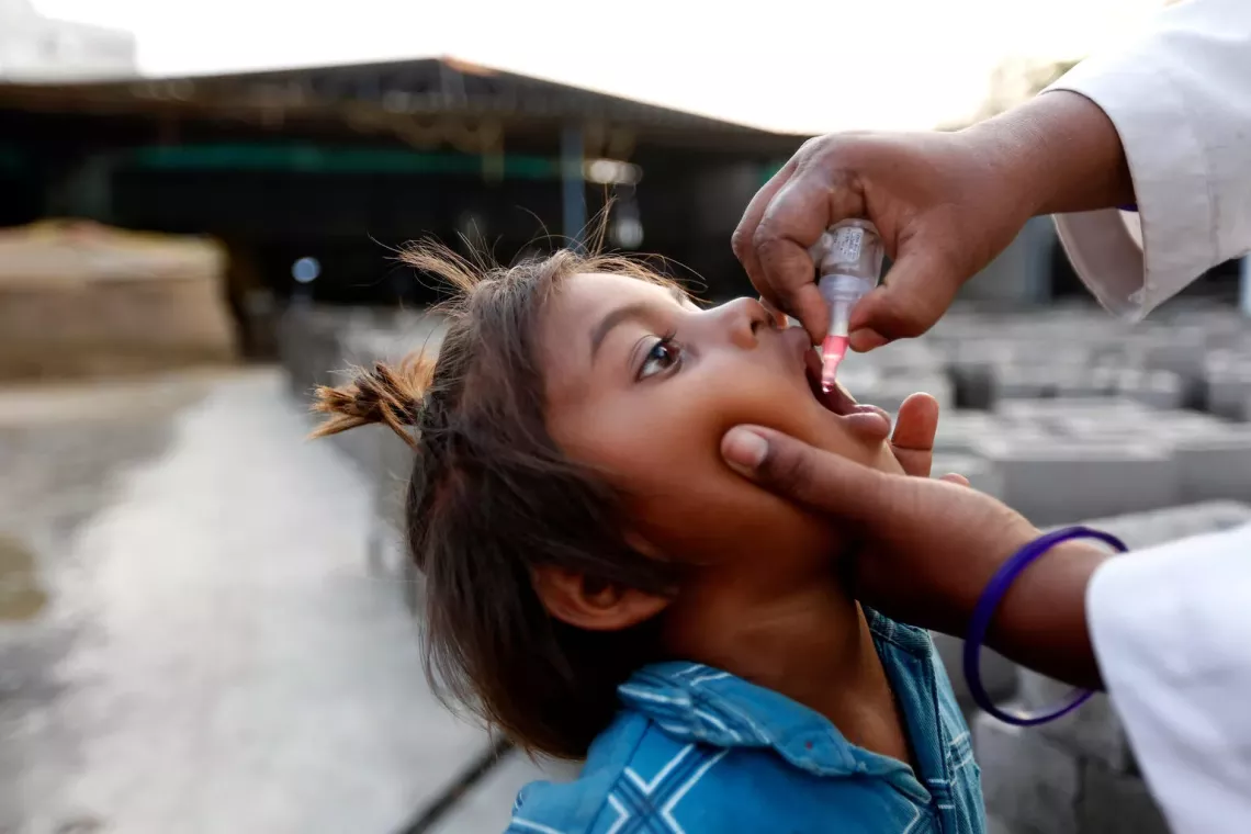 A four-year-old child receives an oral dose of the polio vaccine in India.