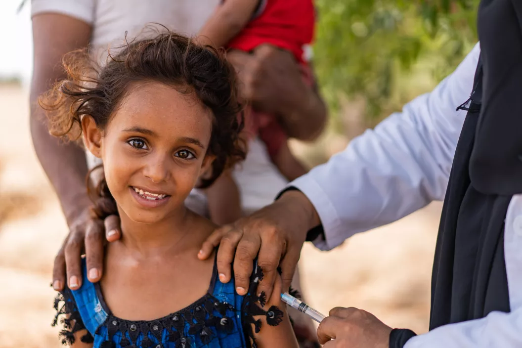 In Aden Governorate, Yemen, health worker Ghada Ali Obaid, 53, vaccinates 7-year-old Hind Ali Nasser during a community outreach vaccination drive for children.