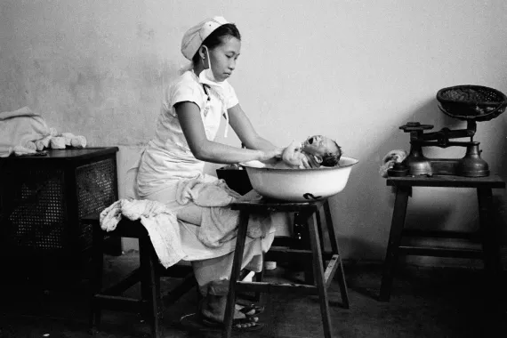 Burma (now Myanmar), 1968. A midwife trainee bathes a newborn baby in the Tower Lane Maternity Hospital in Rangoon. 