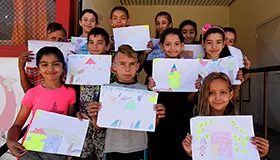 12 children engaged in educational activities in UNICEF supported Child and Youth Zone, in Bulgaria, show they drawings. 