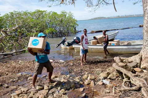 On 23 December 2020, villagers load boxes of UNICEF WASH kits onto fibreglass boats on Tavea village, Bua, Fiji.