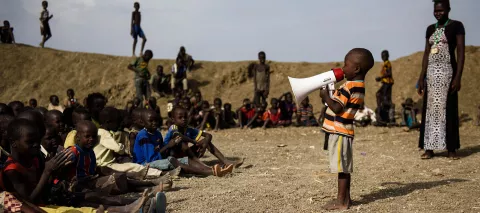 A young boy sings into a megaphone during a dance event organised at a child-friendly space run by UNICEF partner Woman Vision in Bentiu, South Sudan, April 2017. 