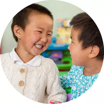 Two small girls smile to each other at an early childhood development center, supported by UNICEF, in Ulaanbaatar, Mongolia, in September 2018.