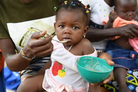 A baby girl is being fed with a spoon