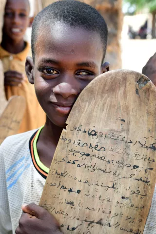Portrait of a young boy who is visually impaired attending his Koranic school